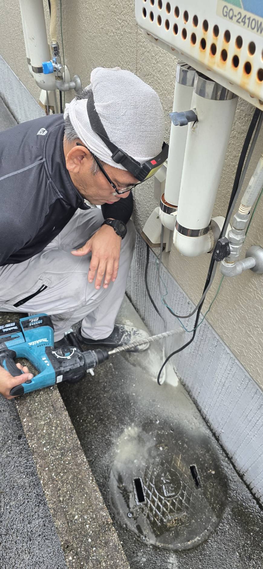 設備まわりで工具を使って作業する職人